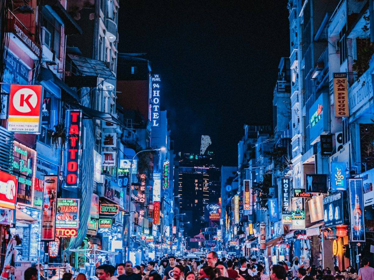 people between city buildings at night