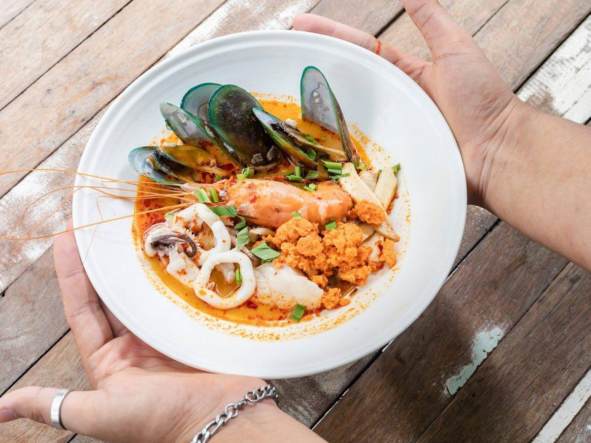 person holding white ceramic plate with food