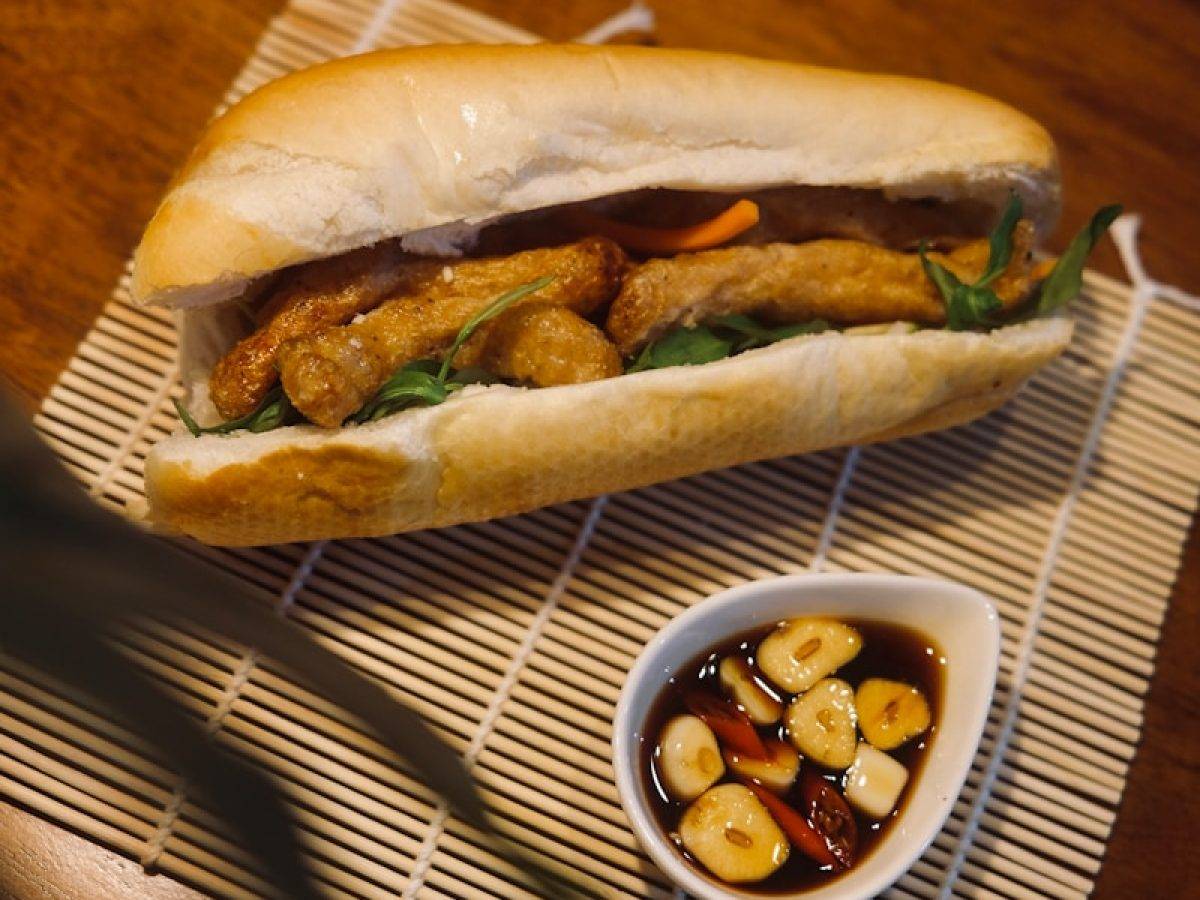 a sandwich and a bowl of food on a table