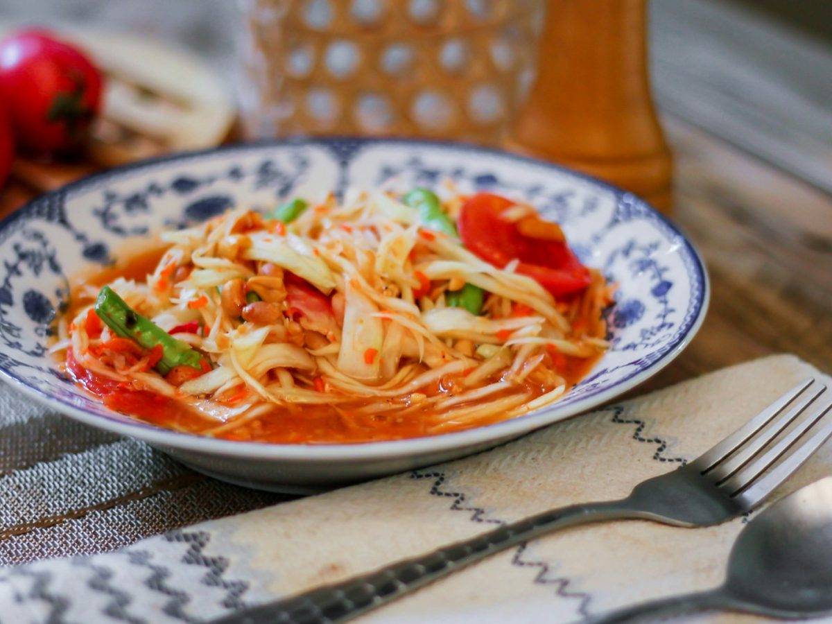 a white and blue bowl filled with pasta and vegetables