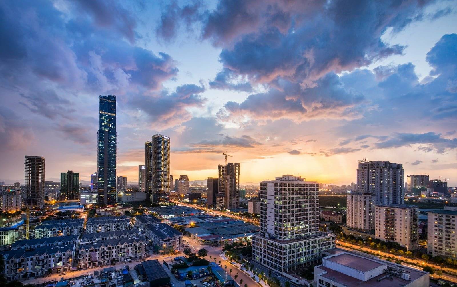 gray high-rise buildings under gray clouds during golden hour