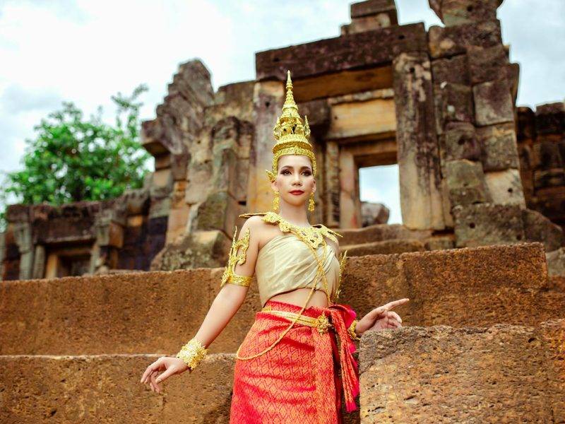 Woman in a Traditional Costume Standing in front of a Temple