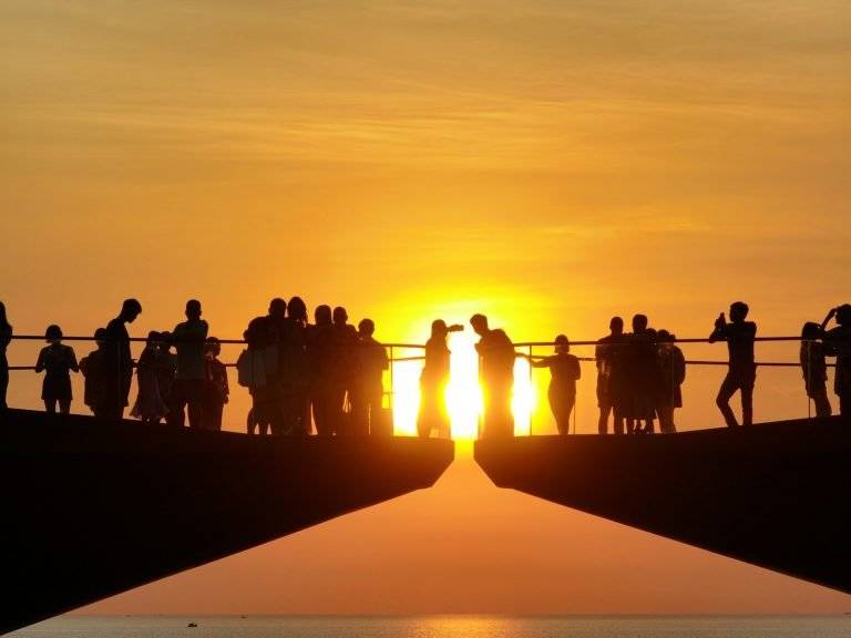 a group of people standing on top of a bridge