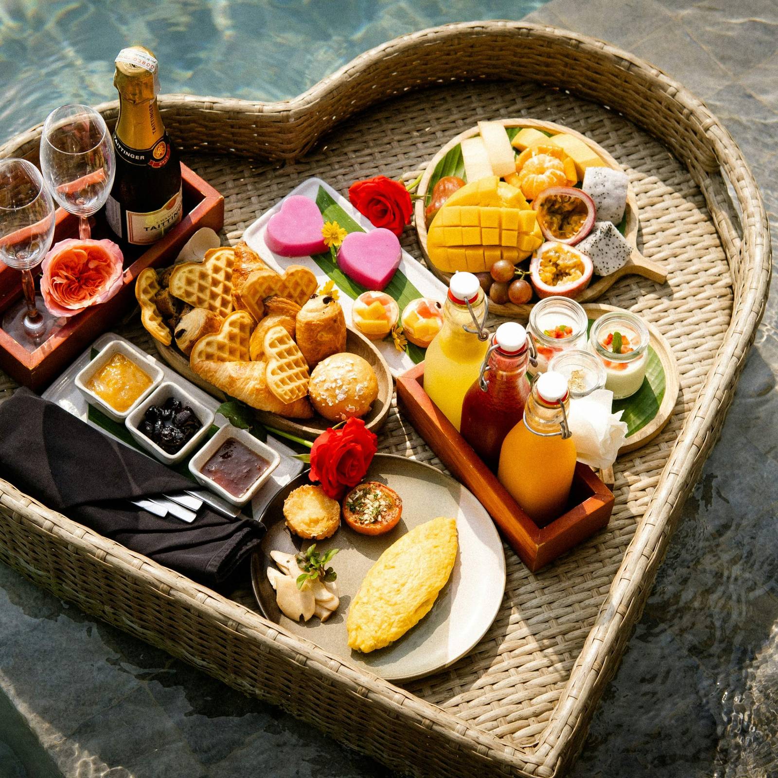 A heart shaped tray filled with food next to a pool