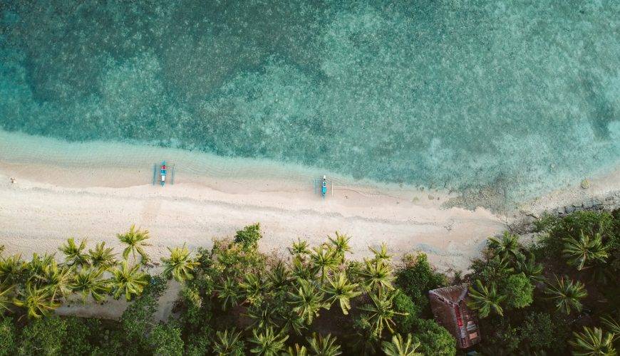 an aerial view of two beach chairs on a tropical beach