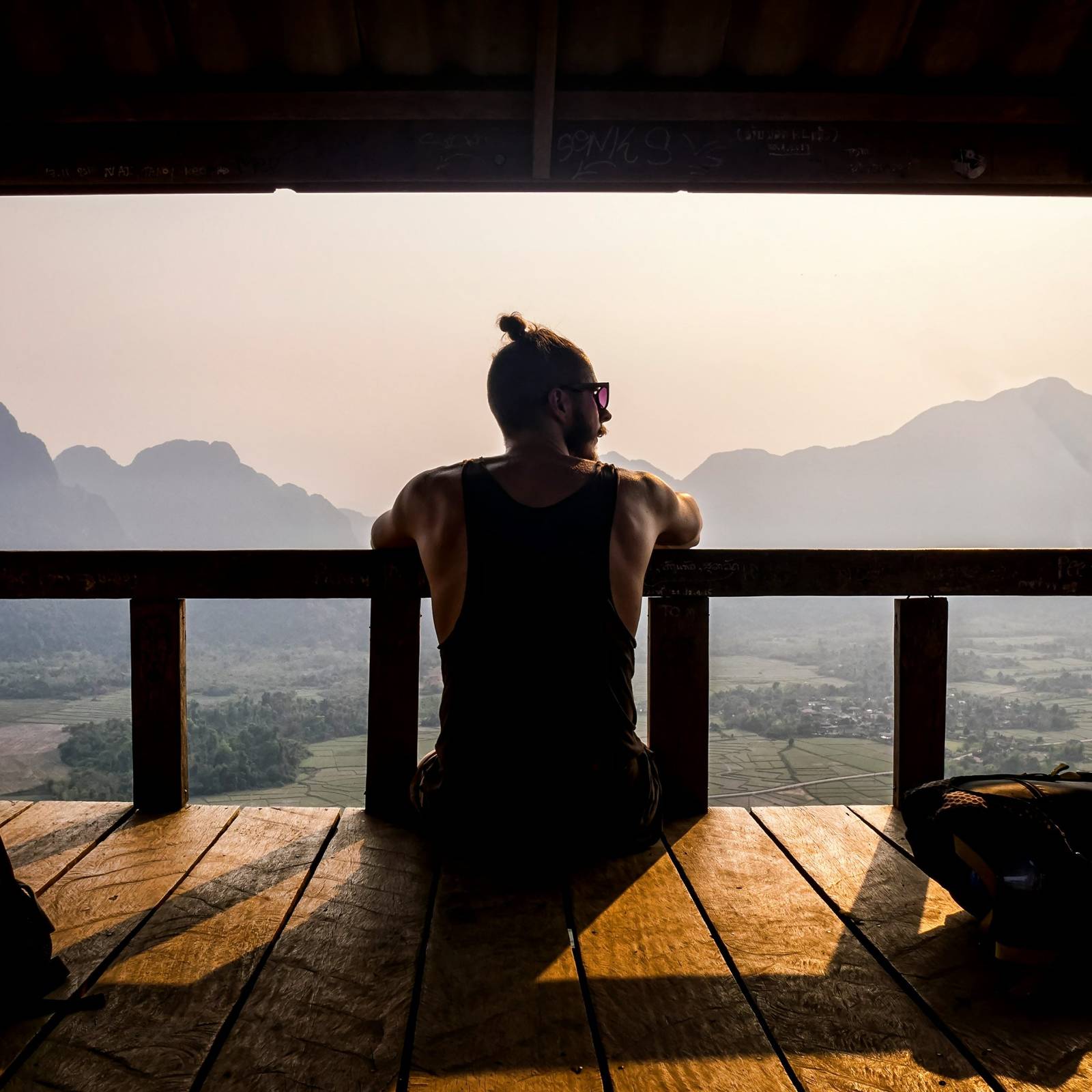 topless man sitting on wooden floor