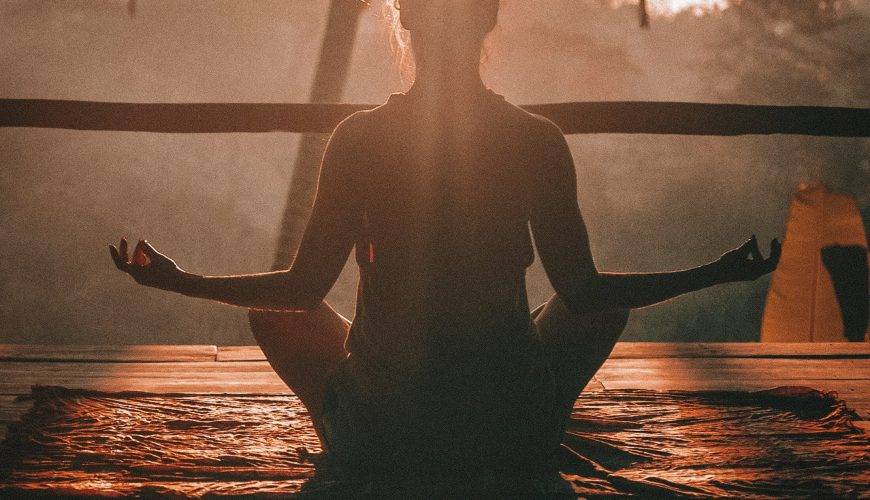 woman doing yoga meditation on brown parquet flooring