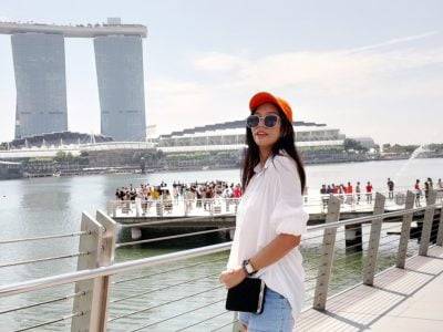 a woman standing on a bridge next to a body of water