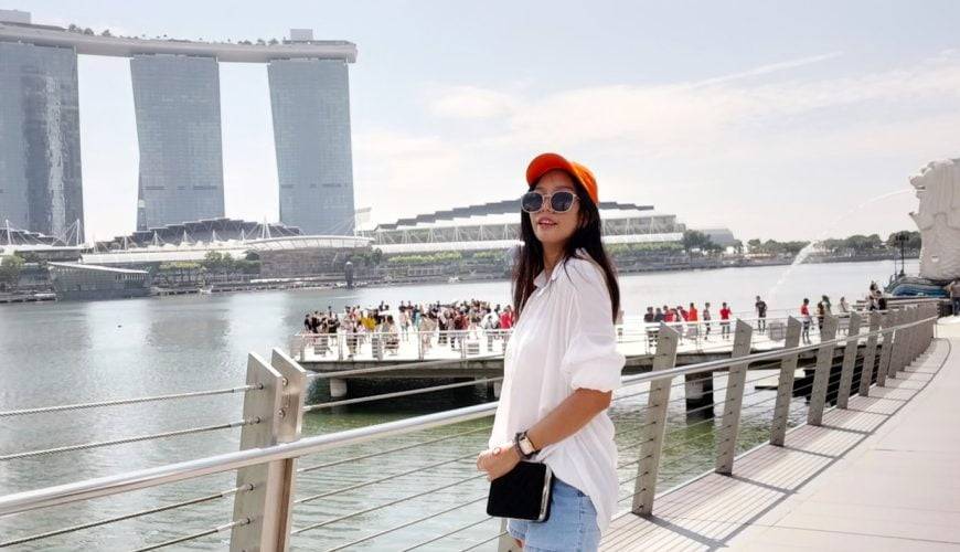 a woman standing on a bridge next to a body of water