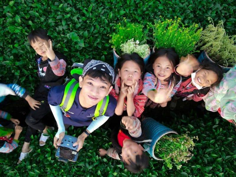 a group of children sitting in the grass